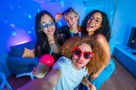 Cheerful multi ethnic friends enjoying a vibrant home disco party, posing for a selfie with colorful...