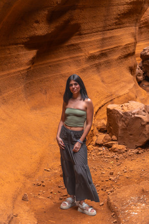 Young woman exploring the unique geological formations of Barranco de las Vacas, a popular tourist destination in Gran Canaria, Spainの写真素材