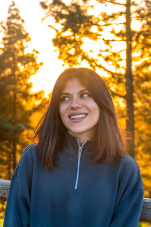 Happy young woman enjoying golden hour sunlight in pine forest of Moya, Gran Canaria, Spain