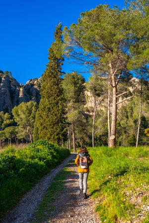 Hiker walking on a path near the montserrat mountains in Catalonia, Spain, enjoying the sunny dayの写真素材