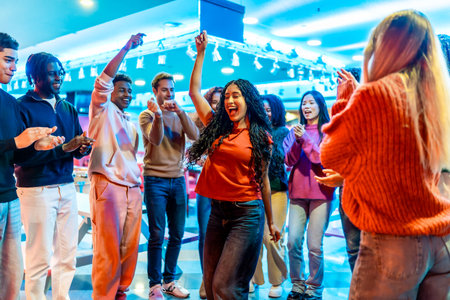 Cheerful multi ethnic friends dancing and enjoying their weekend together at the bowling alleyの写真素材