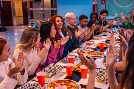Young diverse people celebrating and having fun together at a bowling alley restaurant, enjoying...