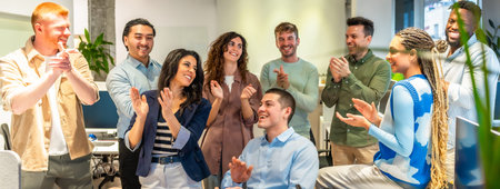 Happy colleagues clapping, celebrating a successful project or good news in a modern office