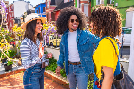 Three happy tourists greeting each other in a residential neighborhood with colorful houses,...