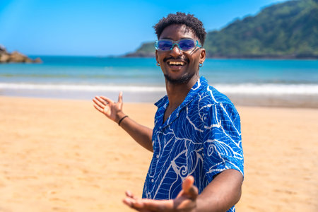 Young black man with sunglasses and hawaiian shirt enjoying summer holidays welcoming people to a...