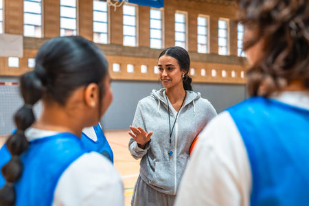 Basketball coach explaining game strategy to his team players during training in a basketball courtの写真素材