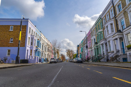 Vibrant pastel colored houses create a picturesque scene along a charming street in Notting Hill, Londonの写真素材