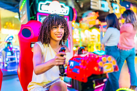 Young woman having fun playing a racing simulator in an amusement arcade with her friends in the backgroundの写真素材