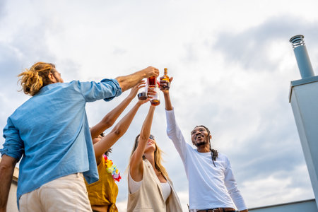 Happy multi ethnic friends raising their glasses for a celebratory toast, enjoying a rooftop partyの写真素材