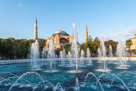 Fountains splashing water in front of the Hagia Sophia in Istanbul, Turkey, during a sunny dayの写真素材