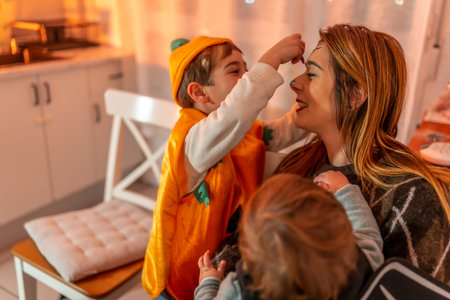 Happy family preparing for a halloween party, applying colorful makeup together at home, creating joyful memories in a cozy atmosphereの写真素材