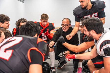 American football coach delivering a motivational speech to a diverse team of young players in their...