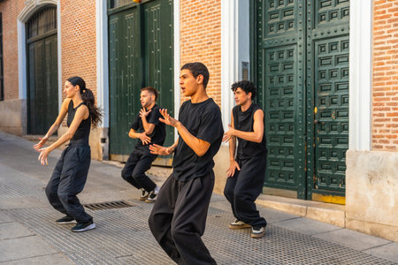 Group of young contemporary dancers moving in sync, expressing their art during a street performance...