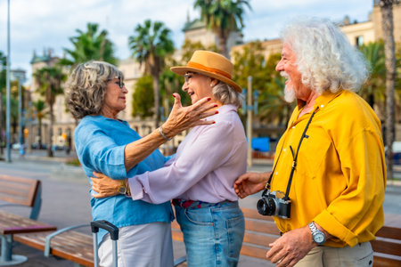 Senior friends embrace in an urban square, joyful reunion while traveling overseas, smiling and celebrating friendship, leisure sightseeing and shared happy momentsの写真素材