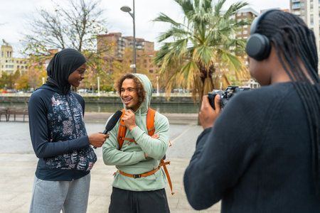 Content creators filming an outdoor interview with a smiling man, capturing diverse perspectives and...