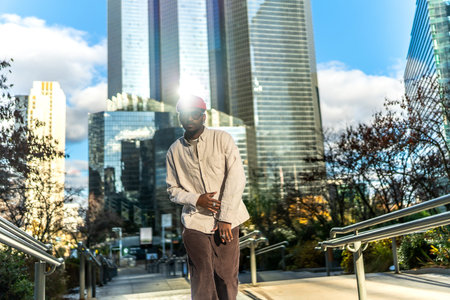 Young man wearing casual street style clothes and sunglasses, looking at camera while posing on...
