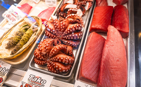 Fresh octopus and tuna fillets are displayed on ice alongside wasabi at a fish market in Vancouver,...