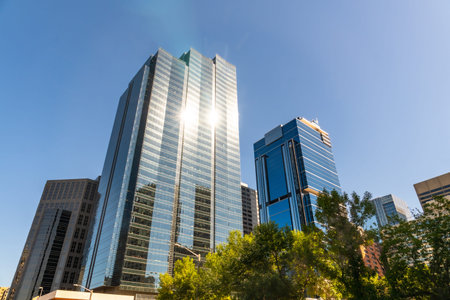 Sun reflecting on glass skyscrapers in downtown Calgary, Canada, creating a vibrant and dynamic...