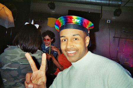 Diverse people celebrating together, enjoying the vibrant atmosphere of a nineties or early two thousands retro party with friends in a dimly lit clubの写真素材