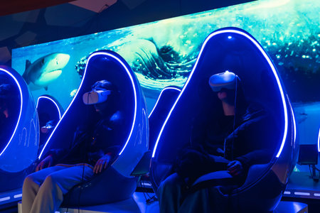 People wearing virtual reality headsets enjoying an immersive deep sea experience while sitting in...