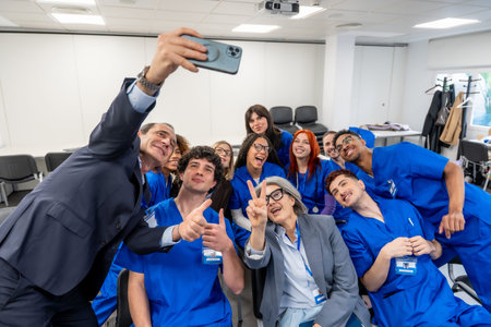 Group of happy young students and experienced healthcare professionals in blue scrubs and formal...