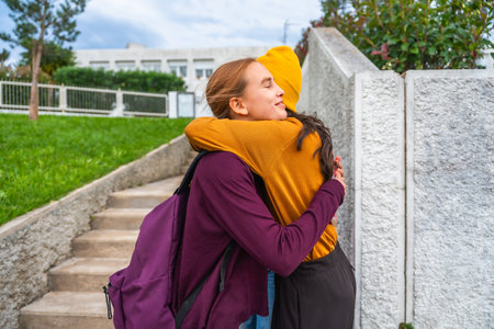 Teenager daughter and mother sharing a warm hug after a school day, showing love, reunion, family bonds, and affection at the entrance of the building, depicting a heartwarming moment