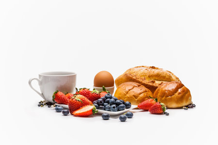 Breakfast with coffee, croissants and berries on white backgroundの写真素材