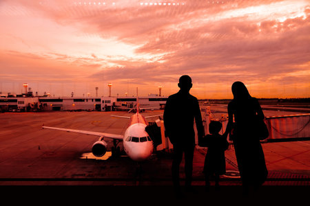 Happy travelers waiting for flight in traveler silhouette airportの写真素材