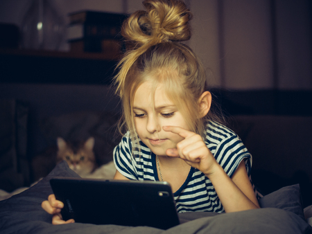 Beautiful blonde girl looking Tablet with catの写真素材