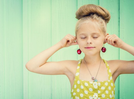 Beautiful girl holding cherries as earrings -style Rockabilly. Space for textの写真素材