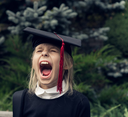 Girl in school uniform wearing graduation cap shout. Education