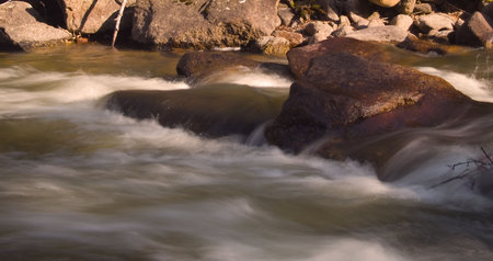 Fast flowing Spring melt off as golden evening light reaches the base of the St. Vrain river canyon...