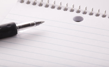 A notebook and black pen in a close up image.