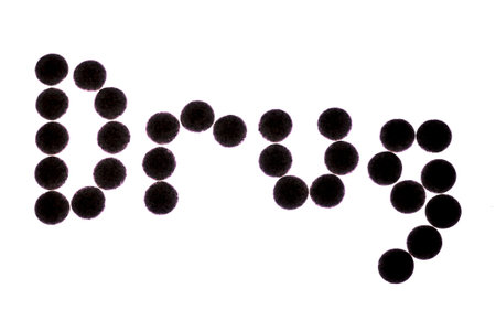 Pills backlit spelling the word drugの写真素材