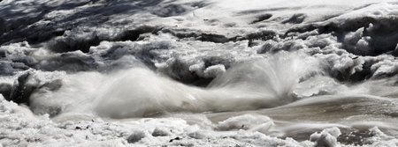 Thawing creek rushing through snow in the North Woods of Minnesota