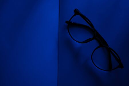 white blank book with Glasses at blue room nightの写真素材