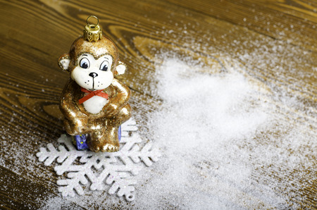 Christmas monkey and a snowflake on a wooden background.の写真素材