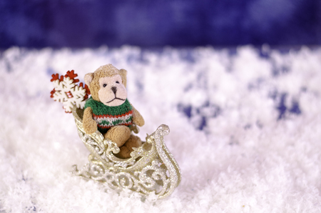Plush monkey in a sleigh on a blurred background.の写真素材