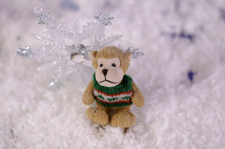 Toy Monkey near shiny snowflake close-up. On blurred background.の写真素材