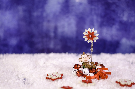 Monkey holding a Christmas wreath in the hands of a snowflake. On a snowy background.の写真素材