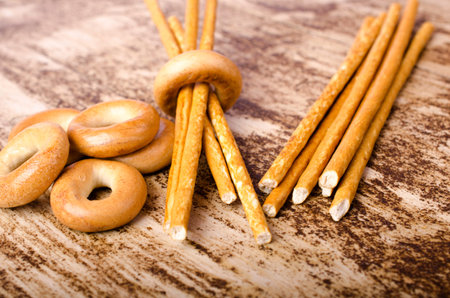 Pile of bagels and sweet sticks on brown background. Close-up.