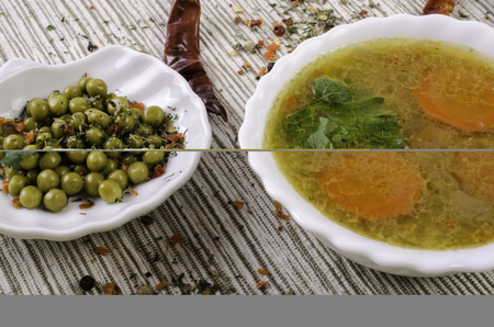 Soup with vegetables, green peas and spices. On gray tablecloth.の写真素材