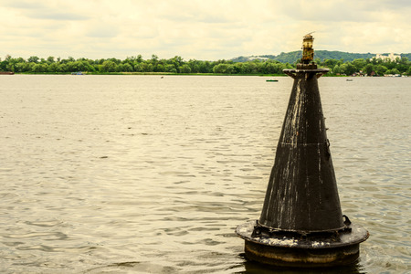 Floating old signal buoy on river marking a fairway. Close-up on water.の写真素材
