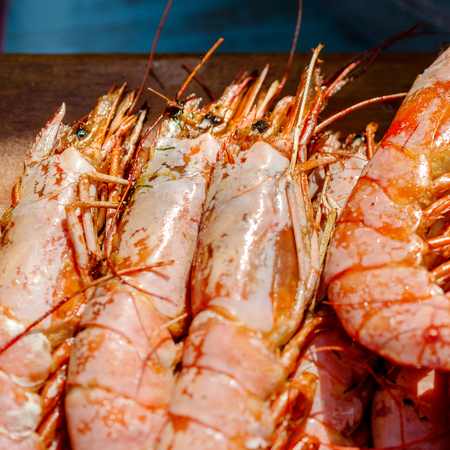Fresh boiled shrimps or prawn. Delicious seafood on a wooden background. Selective focus. Square. Close-up.の写真素材