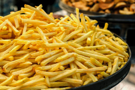 Production of french fries. Large pan of fresh fried sweet potato. Close-up.