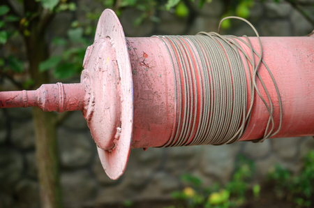 Old coil for manual winch. Equipment for a well in private house. Close-up.