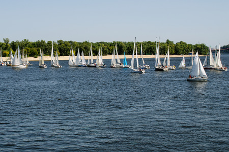 Kiev, Ukraine, August 2018: - many beautiful floating sail yachts medium size with crew , on the Dnieper River. Modern water transport. Horizontal.のeditorial素材