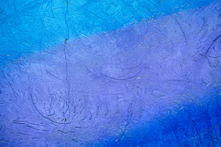 Old cracked plaster wall background. Blue cement wall texture. Close-up.