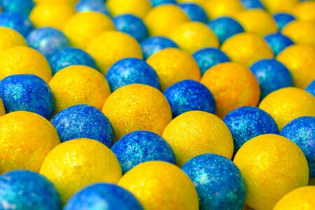 Many of bright blue and yellow balls lying in row diagonally. Multi Colored ball in colors of Ukrainian flag. Selective focus. Close-up.の写真素材