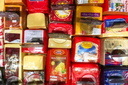 Kiev, Ukraine, January 2020: - Many choice of delicious hard cheese variety in the food counter of the Cosmos supermarket in Kiev, Ukraine. Top view. Close-up. Indoors.のeditorial素材